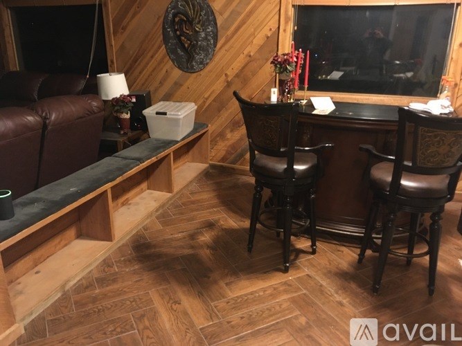 A room with wooden walls and a bench with a black cushion.