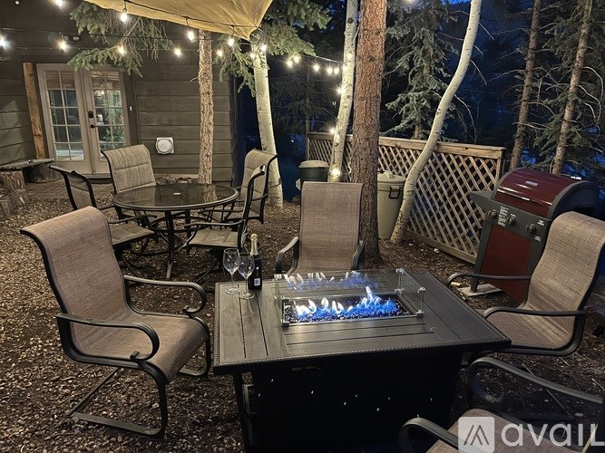 A backyard with a fire pit and chairs.