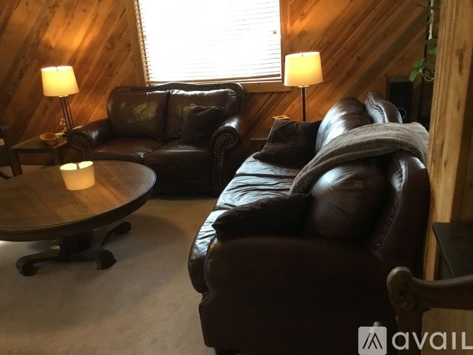 A living room with a brown leather couch and a wooden coffee table.