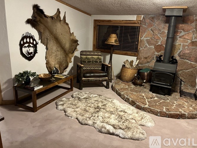 A room with a stone fireplace and a large animal skin rug.