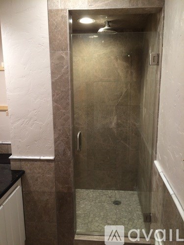 A bathroom with a tiled floor and a walk-in shower.