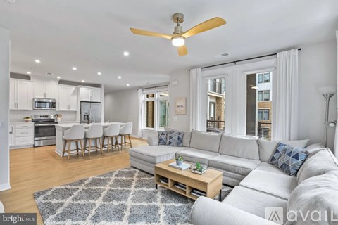 A bright and modern living room with a grey sofa and a wooden coffee table.