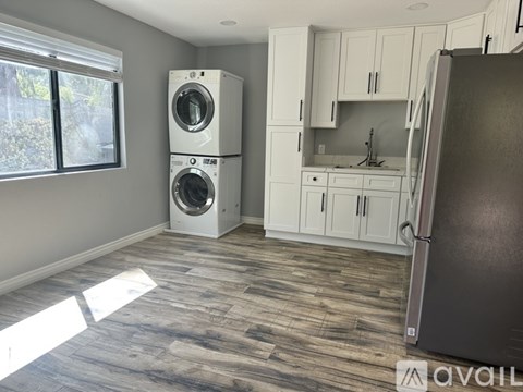 A kitchen with a washer and dryer stacked on top of each other.