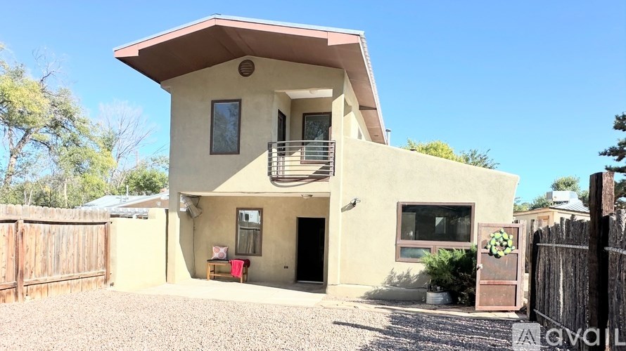 A house with a brown roof and a gravel driveway.