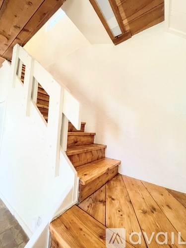 A wooden staircase with a white railing.