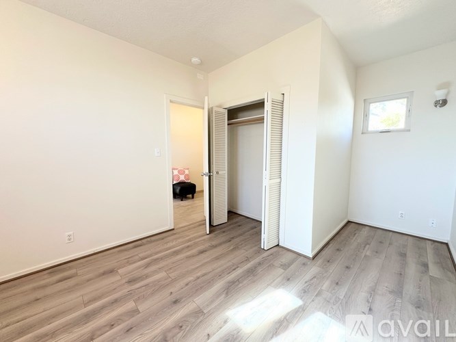 A room with a wooden floor and white walls is available for rent.