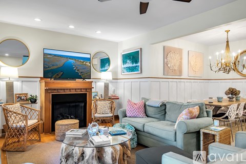 A living room with a fireplace, a couch, and a painting on the wall.