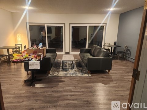 A living room with a black sofa, a coffee table, and a rug.