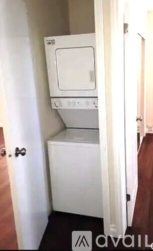 A small white kitchen with a microwave and oven built into a cabinet.