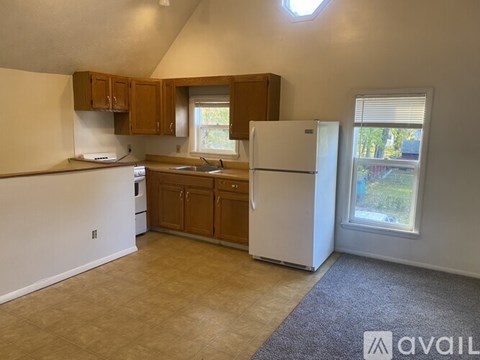 A kitchen with white appliances and wooden cabinets.