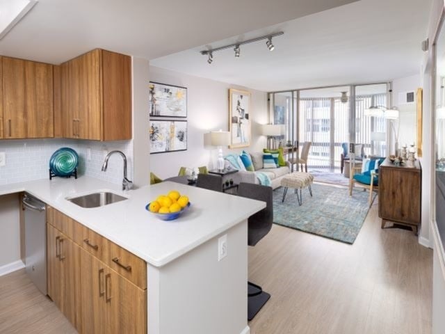 A kitchen with a white counter top and wooden cabinets.