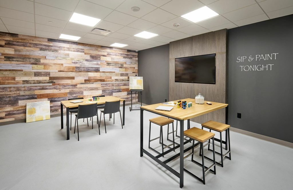 A room with a wooden wall and a sign that says "Sip & Paint Tonight".