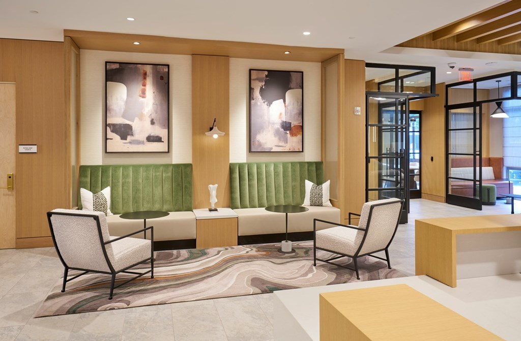 A modern waiting room with a green sofa and two chairs.