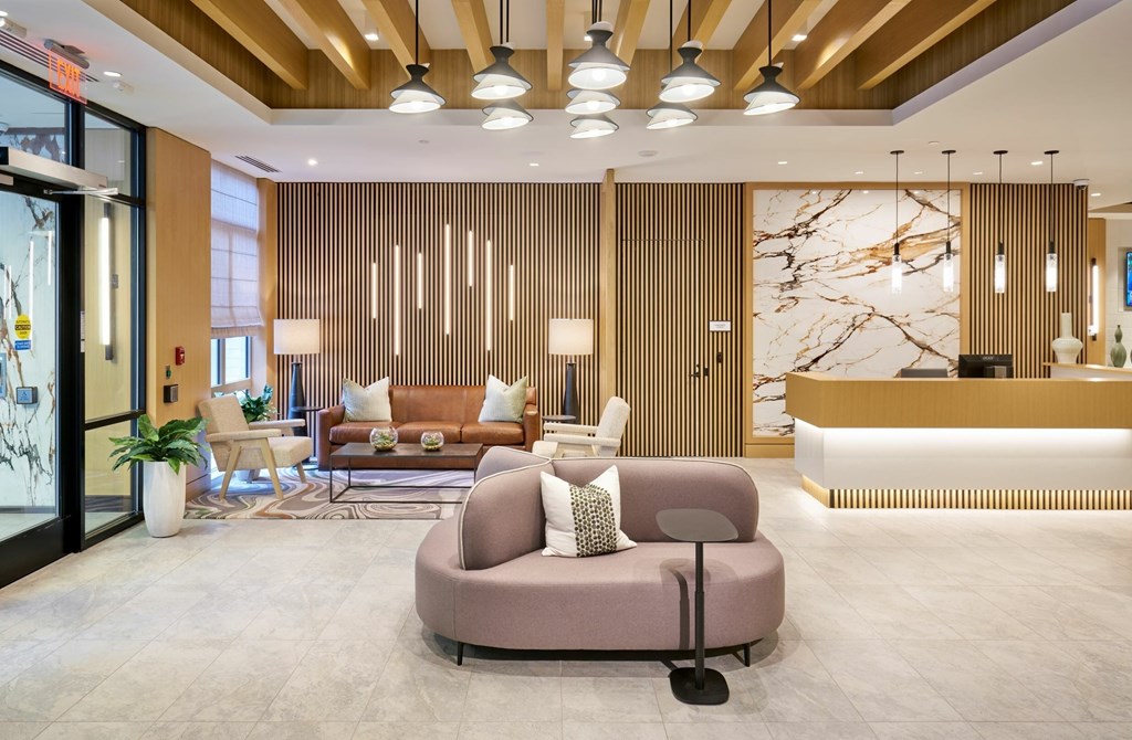 A modern living room with a large sofa and a reception desk.