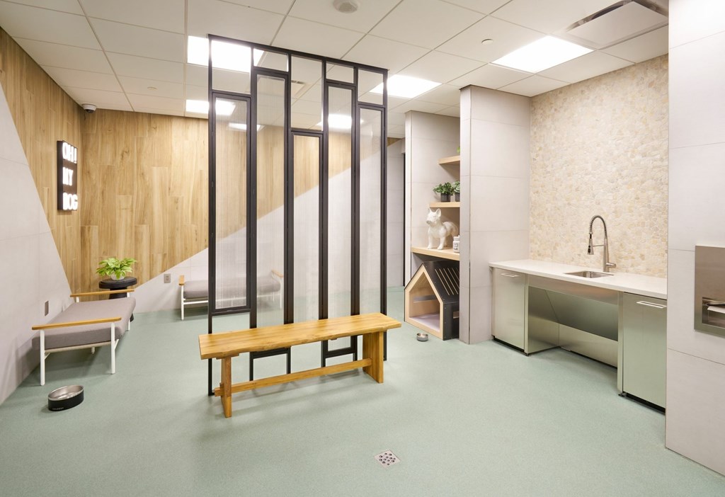 A room with a wooden bench and a glass partition.