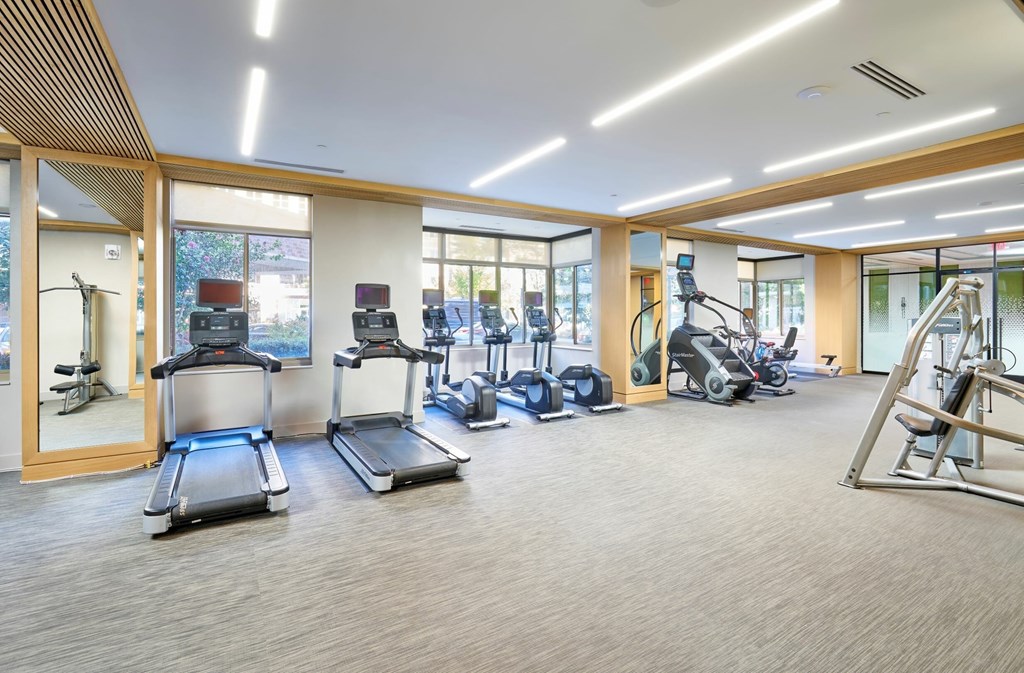 A spacious gym with treadmills, exercise bikes, and other equipment.