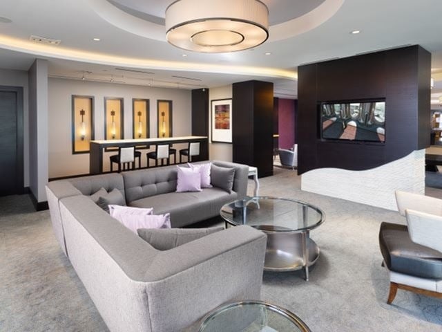 A modern living room with a grey sofa and a glass coffee table.