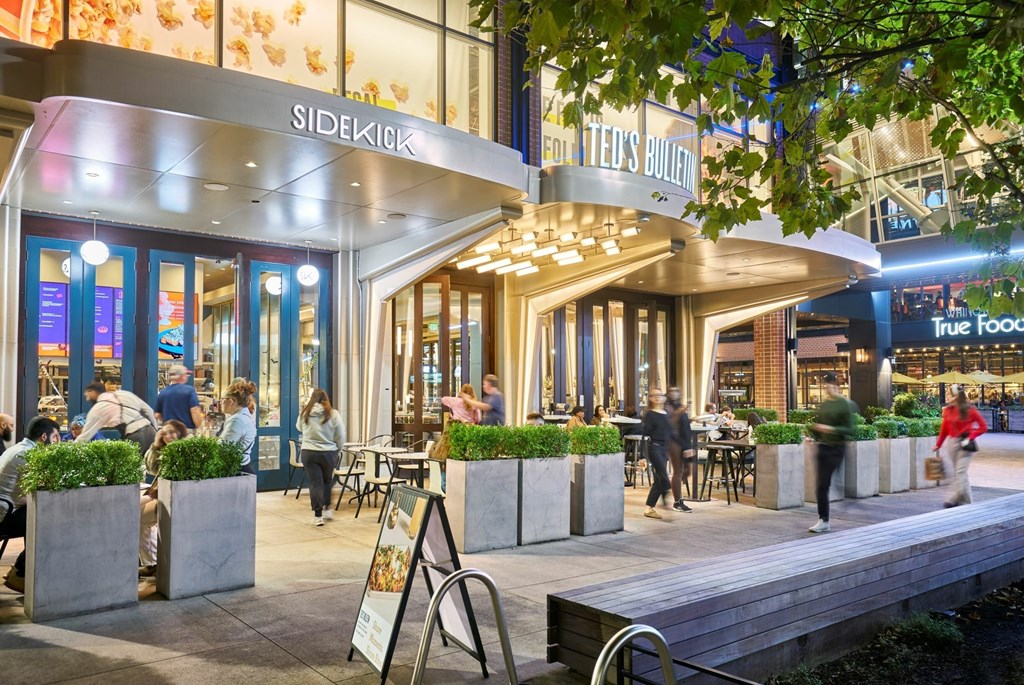 A restaurant named Sidekick is bustling with people enjoying their meals.