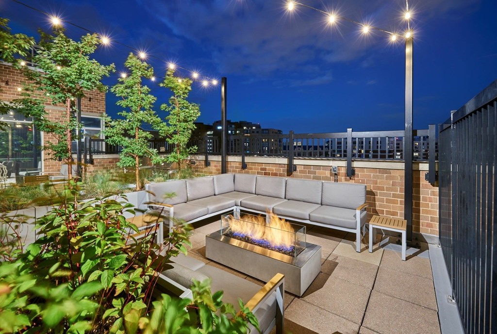 A patio with a fire pit and seating area.