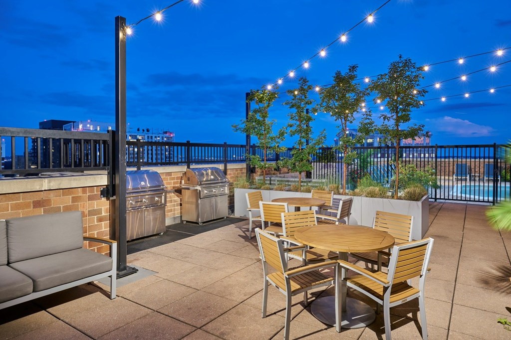 A patio with a table and chairs is set up on a rooftop.