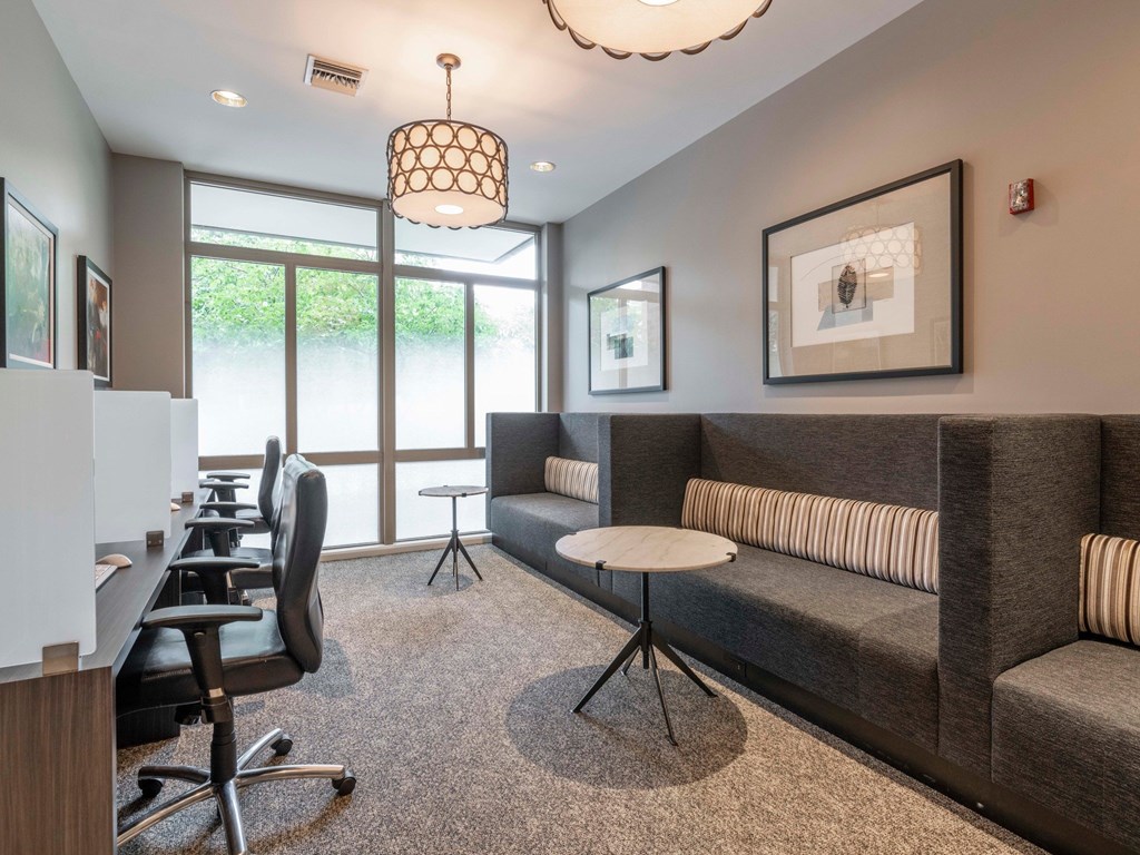 A modern living room with a grey couch and a round table.
