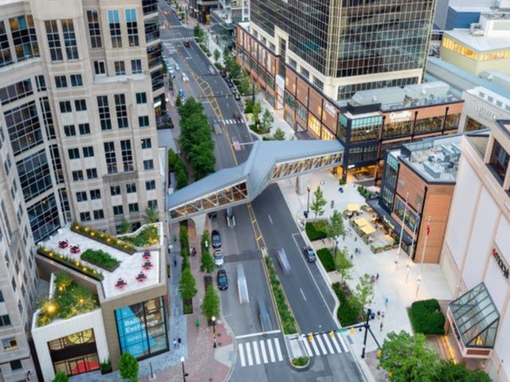 A city street with a pedestrian crossing and buildings on either side.