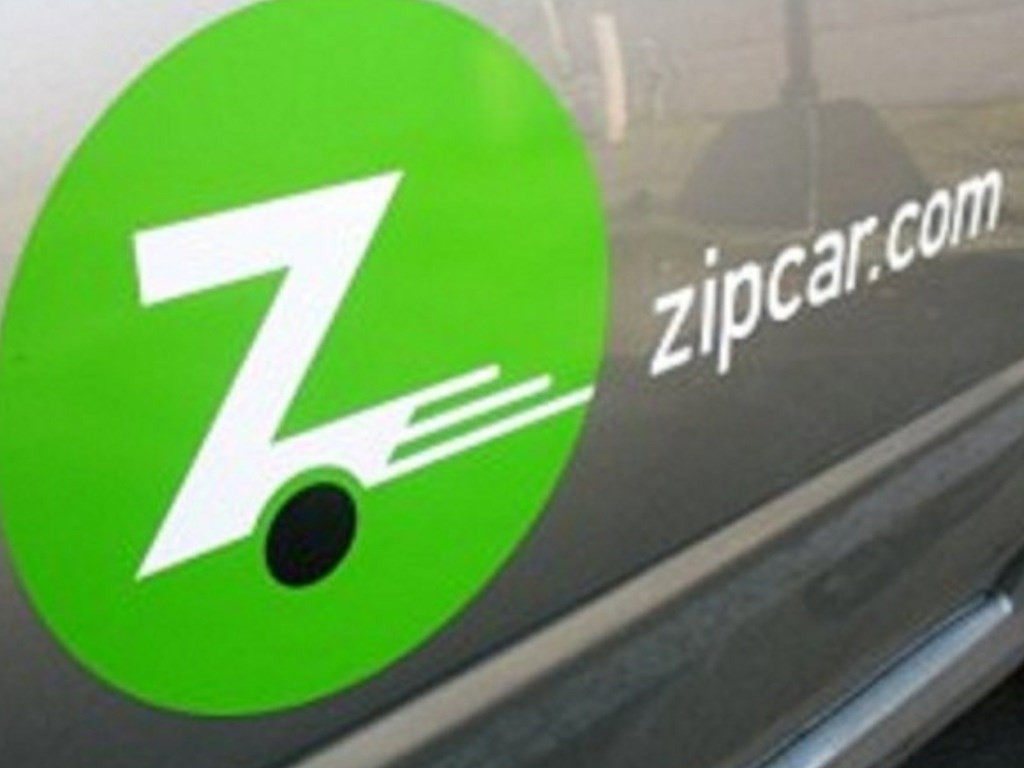 A green circle with a white Z and a white car on the right.