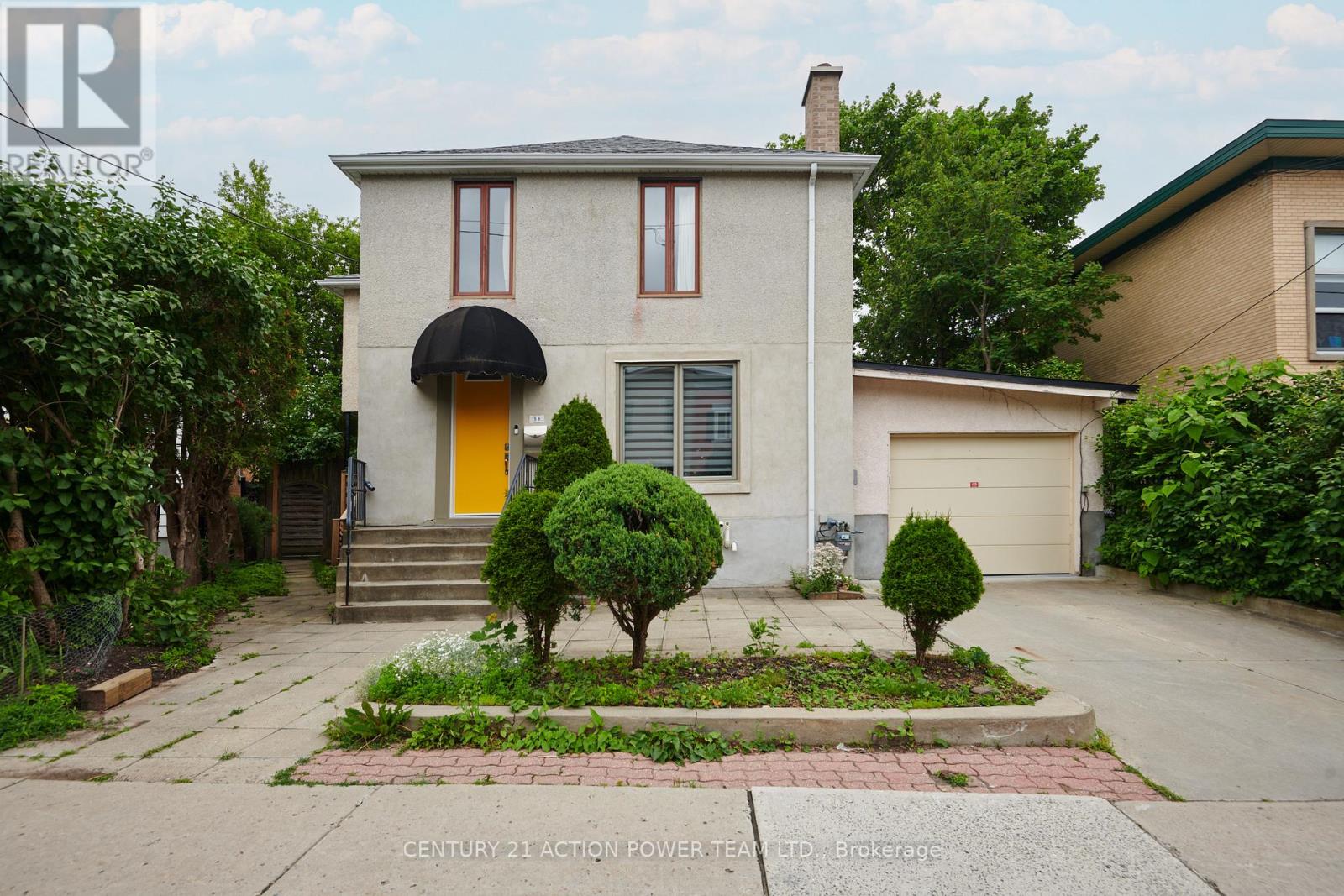 A house with a yellow door and a small garden in front.