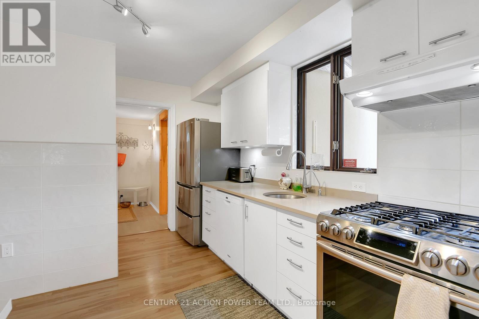 A modern kitchen with white cabinets and a stainless steel stove.