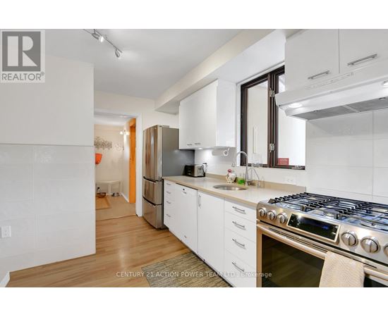 A modern kitchen with white cabinets and a stainless steel stove.