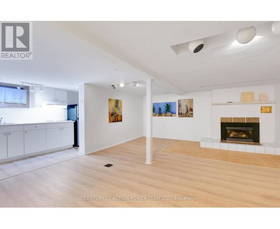A spacious living room with a fireplace and a painting on the wall.