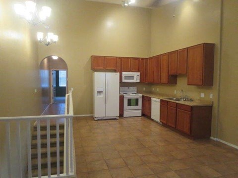 A kitchen with brown cabinets and a white fridge.