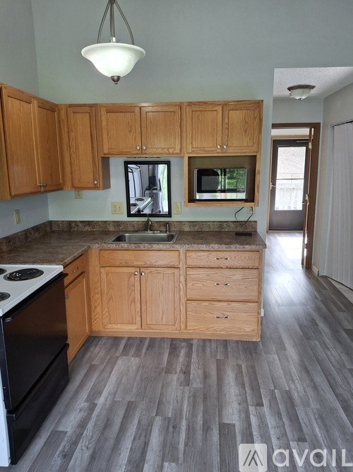 A kitchen with wooden cabinets and a granite countertop.