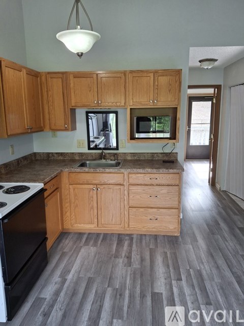 A kitchen with wooden cabinets and a granite countertop.