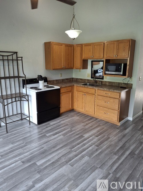 A kitchen with wooden cabinets and a black stove top oven.