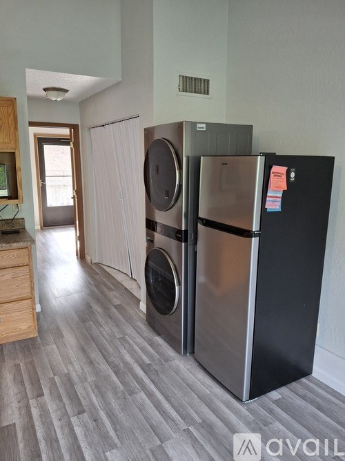A kitchen with a black fridge and a stainless steel dishwasher.
