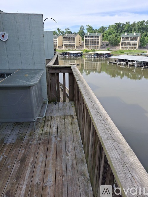 A wooden deck overlooks a body of water with buildings in the distance.