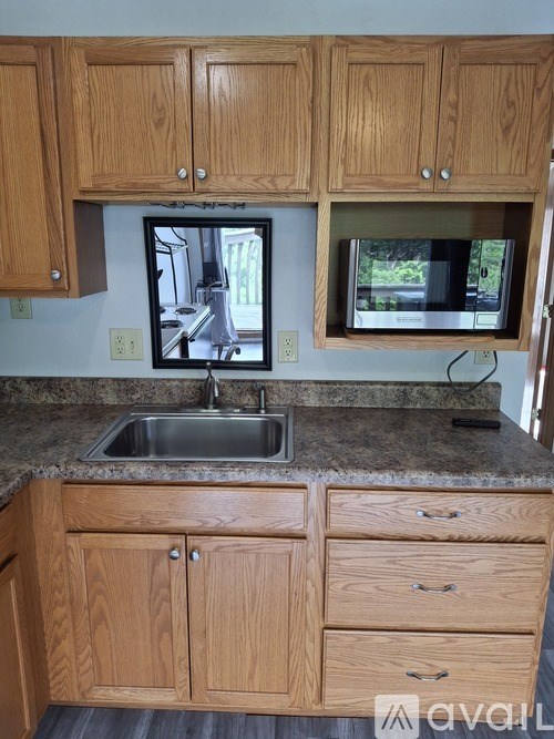 A kitchen with wooden cabinets and granite countertops.