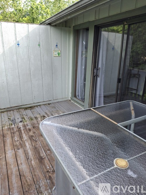A hot tub on a wooden deck outside a house.