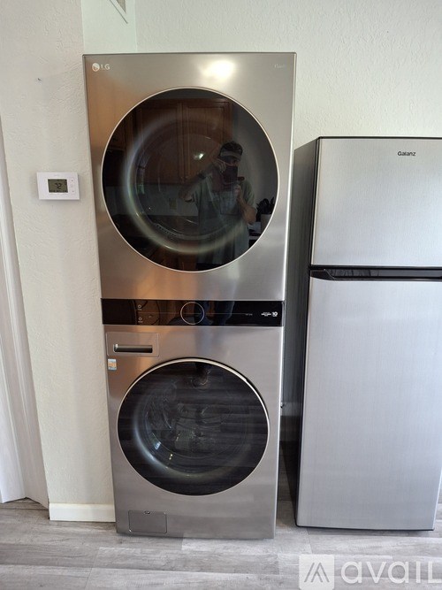 A stainless steel dishwasher and fridge in a kitchen.