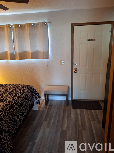 A bedroom with a bed, bench, and door.