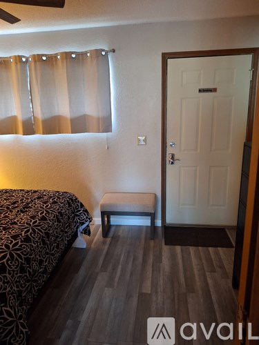 A bedroom with a bed, bench, and door.