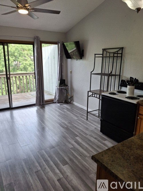A kitchen area with a fan and a counter with a sink.