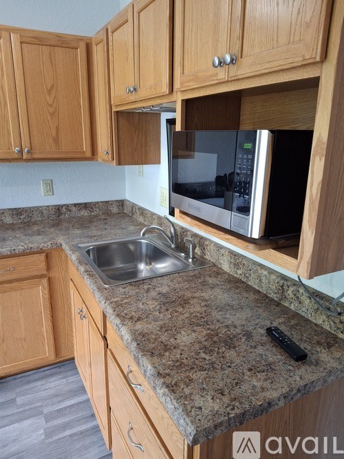 A kitchen with granite countertops and wooden cabinets.
