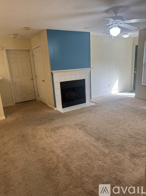 A room with a fireplace and a ceiling fan.