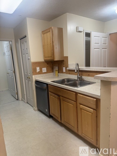 A kitchen with wooden cabinets and a white countertop.