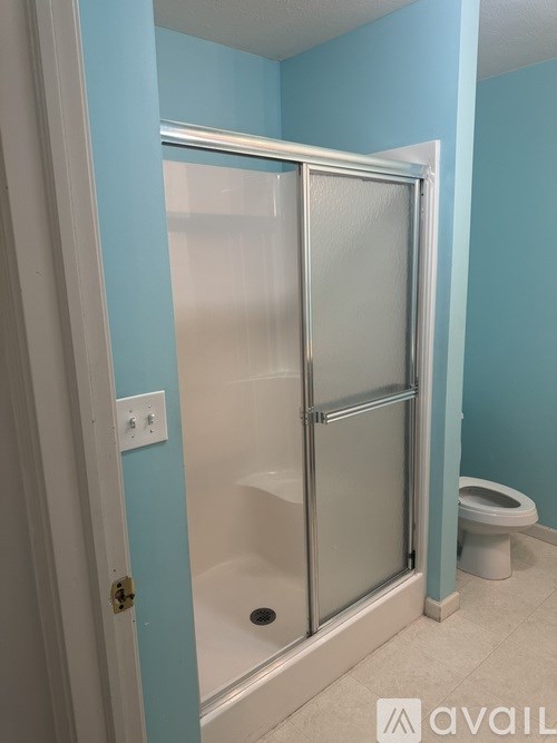 A bathroom with a blue wall and a white toilet.
