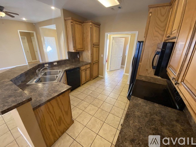 A kitchen with wooden cabinets and a black refrigerator.