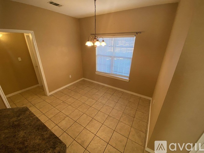 A room with a tiled floor and a window with blinds.