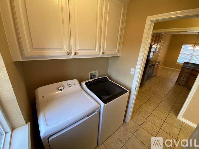 A white dishwasher and a black dishwasher are in a kitchen.